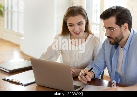 Happy two colleagues working together on computer. Stock Photo