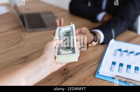 Corrupted black businessman sealing deal, receiving bribe money from partner Stock Photo