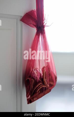 dried orange slices in potpourri red mesh bag hanging from bathroom door Stock Photo