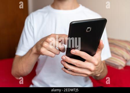 Unrecognizable male using a tablet in his bedroom Stock Photo