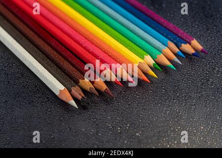 Colored pencils on a black background. Creative activities for children on vacation and in quarantine. Children's creativity, needlework project. Copy Stock Photo