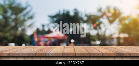 Empty wood table and defocused bokeh and blur background of garden trees in sunlight, display montage for product. Stock Photo