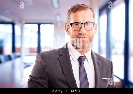 Close-up of executive businessman wearing suit and tie while standing in the office. Stock Photo