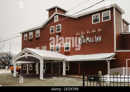 Baldwinsville, New York, USA. February 7, 2021. The local landmark hotel ,  The Red Mill Inn between the Seneca River and Erie Canal Lock 24 in Baldwi Stock Photo