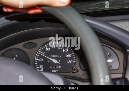 Hand on the handlebars in the car. Speedometer and steering wheel. Stock Photo