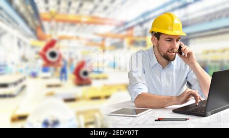 engineer at his workplace with notebook in an industrial company in mechanical engineering Stock Photo