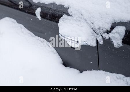 08 February 2021, Lower Saxony, Osnabrück: The driver's door of a parked car is almost completely covered with snow. Photo: Jonas Walzberg/dpa Stock Photo