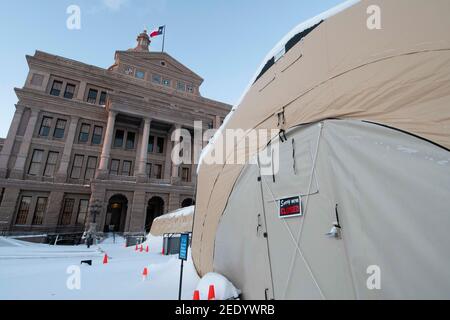 Austin, Texas USA Feb 15, 2021: The north Texas Capitol grounds including a COVID-19 testing tent are covered in 6-7 inches of rare snowfall Monday morning after an overnight winter storm blew into central Texas. The accompanying frigid weather wreaked havoc on the state's electricity grid, causing massive power outages to millions of customers across the state. Credit: Bob Daemmrich/Alamy Live News Stock Photo