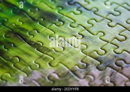 Jigsaw puzzle. Closeup of green jigsaw puzzle peices. Conceptual photo with focus on completed puzzle Stock Photo