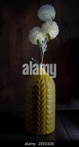 Bouquet of white flowers in a jug isolated against a wood effect background. Stock Photo