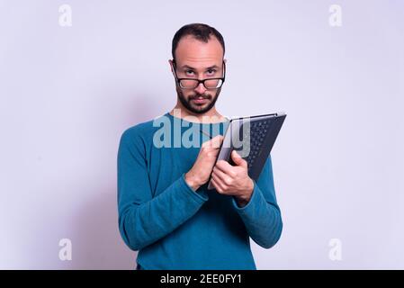 man using ipad or tablet on white background with glasses with casual clothes. account or office worker Stock Photo