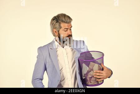 Destroy evidence. Insure important documents. Recover files after deletion. Businessman hold trash can. Man look for lost document in paper bin. Office worker digging in garbage bin. Recover document. Stock Photo