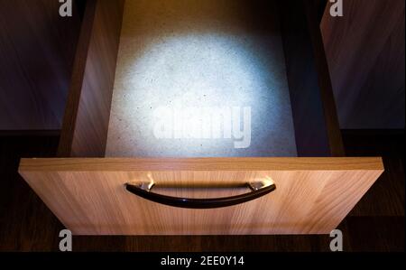 Empty Opened Drawer of the Furniture with a Spot of the Light Stock Photo