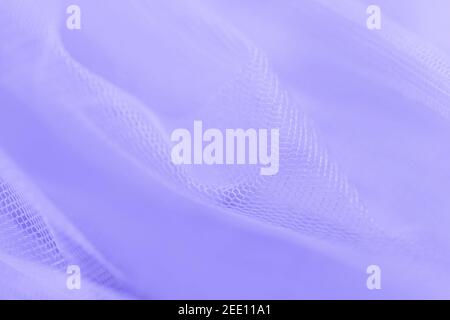 Light small mesh fabric on violet background. Stock Photo