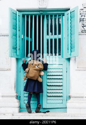 Little girl peering into a window, Varanasi, India Stock Photo