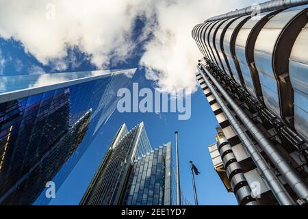 Dramatic upwards view of tall commercial buildings reaching up into a blue sky with fluffy white couds Stock Photo