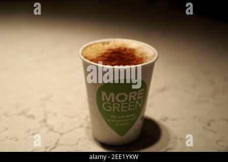 DUBLIN, IRELAND - Jan 11, 2020: Close up view of take away coffee on the table. The coffee is served in the recyclable paper cup with visible text "Mo Stock Photo