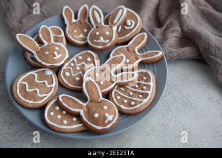 Chocolate cookies in the shape of bunnies and eggs for the Easter holiday on a gray plate and a stone background Stock Photo