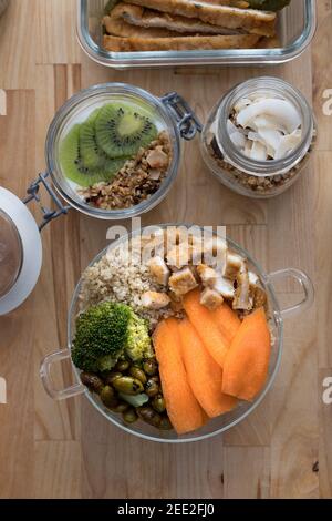 Three and a half glass containers full of healthy food over a wooden table. Stock Photo
