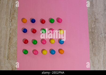 Candy is arranged on colorful paper creating repetitive patterns. Series.