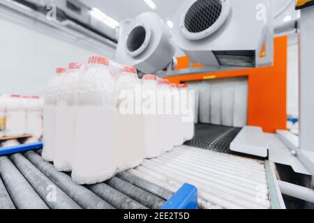 Dairy factory industry, automatic packaging of bottles with milk in plastic bags. Stock Photo