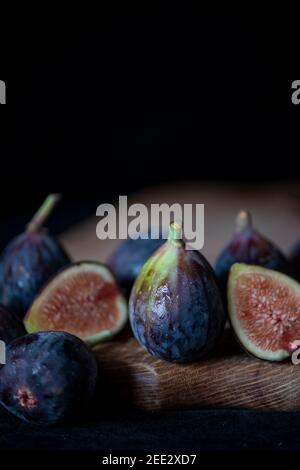 Still life with fresh figs on a wooden cutting board. Stock Photo
