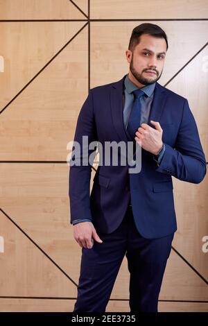 executive in formal wear posing, after meeting with successful people. caucasian male stands looking at camera confidently. success, business, eleganc Stock Photo