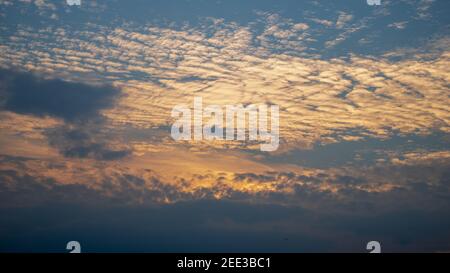 Sun setting behind the clouds in the sky over Suffolk Uk Stock Photo