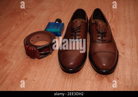 Brown men's shoes. belt. perfume. wedding rings. Groom's accessories Stock Photo