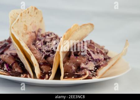 Traditional Mexican birria tacos with coriander and onion on top. Street food from Mexico. Comforting food. Stock Photo