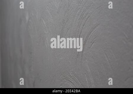 Decorative plaster. Wall with rounded plaster stripes, painted dark gray. Selective focus. Stock Photo