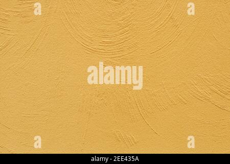 The texture of the plastered yellow wall. Decorative plaster using rounded stripes technique. Trending color of 2021 Stock Photo
