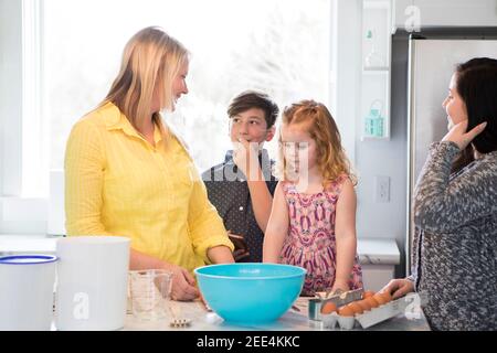 Mom and kids baking in the kitchen. Stock Photo