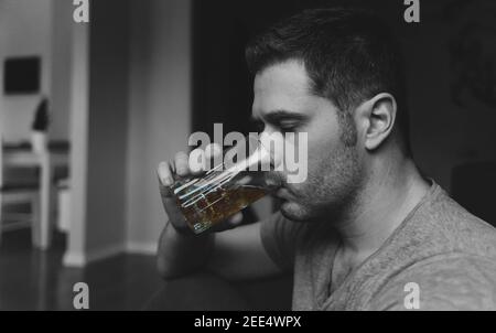 Exhausted drunk man with glass of whiskey. Alcoholism concept. Stock Photo