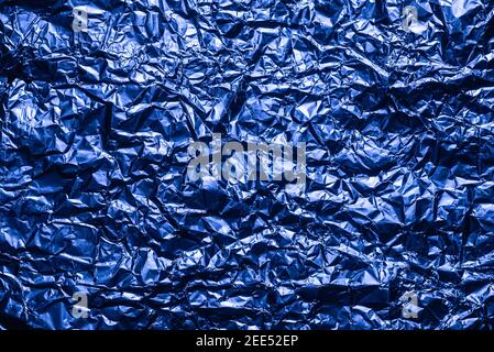 Blue foil background with the shiny crumpled surface for texture background. Iridescent surface wrinkled foil. Stock Photo