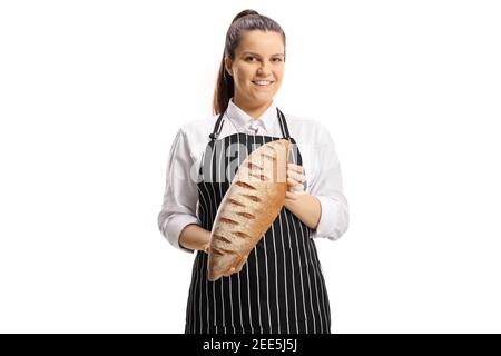 Young female baker wearing an apron and holding a loaf of brown bread isolated on white background Stock Photo
