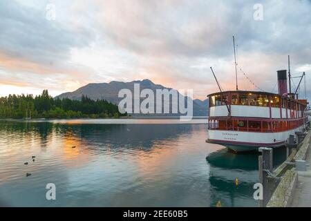 Queenstown New Zealand - March 1 2015; Vintage tourist boat TSS Earnslaw parked at pier in township by Lake Wakatipu in morning light before days sail Stock Photo
