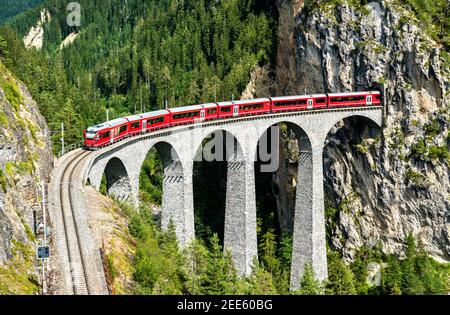 Passenger train crossing the Landwasser Viaduct in Switzerland Stock Photo