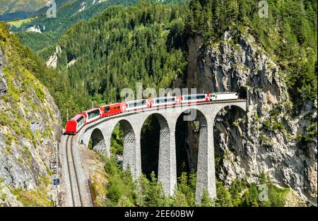 Passenger train crossing the Landwasser Viaduct in Switzerland Stock Photo