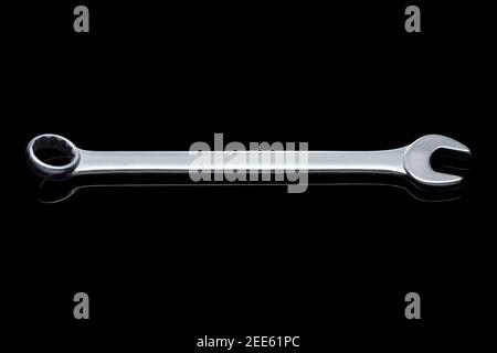 spanner wrench iron hand tool for repair and service plumbing instrument isolated on black glass background with reflection and copy space, nobody. Stock Photo