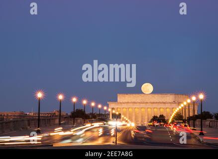 The full moon rises above Arlington Memorial Bridge and The Lincoln Memorial. Stack of 5 images each taken minutes apart. Stock Photo