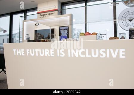 Belarus. Minsk. January, 2021 - Disabled Inclusion works as a barista in an inclusive cafe. The barista calculates the buyer at the terminal. A place where all employees are people with disabilities. Managed by a person with Down syndrome. All baristas are wheelchair users. Stock Photo