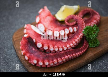 Octopus food cooked salad seafood squid cuttlefish dinner restaurant, Boiled octopus tentacles with lemon on plate background Stock Photo