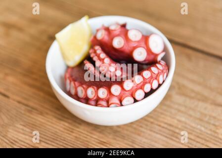 Boiled octopus tentacles with lemon on plate background, Octopus food cooked salad seafood squid cuttlefish dinner restaurant Stock Photo