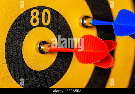 Close up image of a dart game in which one of the arrows hit the bullseye. A vibrant versatile image useful for competition, struggle, hard work, succ Stock Photo