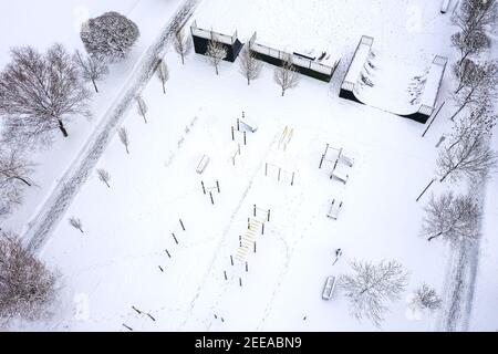 outdoor sports ground and skatepark covered with snow in winter. aerial view from flying drone Stock Photo