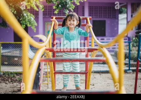 School kids play and learn in the playgound. Physical activity like climbing are good for develop movement and muscle in children Stock Photo