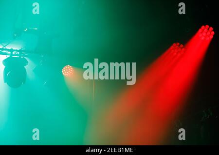 LED stage lighting fixtures hanging on the farm. Red beams of light and green flood light. Stock Photo