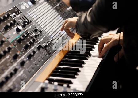 Playing music on the keyboard of a modern analog synthesizer. Selective focus. Stock Photo