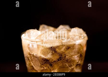 Close up of cold sparking cola sodar soft drink in the glass with foam bubble on top Stock Photo